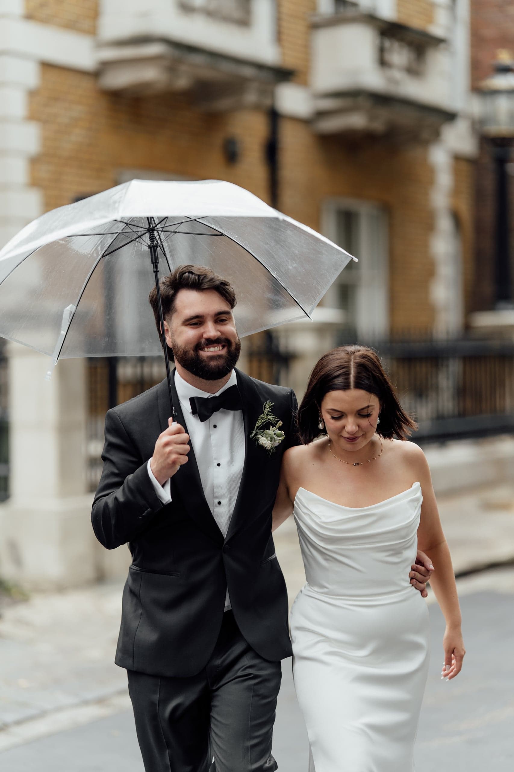 Kirsty and Jamie sheltering under an umbrella near the Trafalgar Tavern